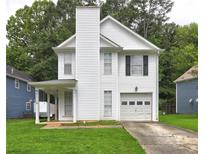 Charming two-story home with a well-manicured lawn and a classic white exterior at 5026 Brittany Dr, Stone Mountain, GA 30083