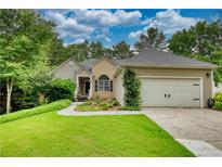 Charming one-story home featuring a manicured lawn, attached two-car garage, and inviting front porch at 1248 Rockview Ct, Loganville, GA 30052