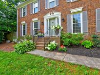 Charming brick home featuring a welcoming front entrance with manicured landscaping and gray shutters at 4512 Woodlawn Lake Dr, Marietta, GA 30068