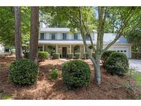 Traditional two-story home with white siding, blue shutters, and a welcoming front porch at 9165 Eves Cir, Roswell, GA 30076