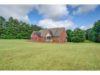 Charming brick home with a large, lush green lawn surrounded by mature trees at 172 Lakeview Dr, Newborn, GA 30056