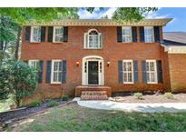 Charming brick two-story home with symmetrical design and a well-manicured front yard at 2935 Abbottswell Dr, Alpharetta, GA 30022
