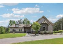 Charming single-story home with gray siding, stone accents, manicured lawn, and well-maintained landscaping at 411 Johnson Rd, Locust Grove, GA 30248