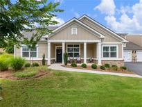 Charming home with a covered porch, manicured lawn, and well-maintained landscaping at 1802 Lexington Green Pnes, Cumming, GA 30040