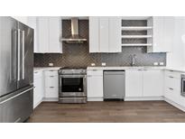 Modern kitchen featuring stainless steel appliances, white cabinetry, and stylish herringbone backsplash at 788 W Marietta Nw St # 1404, Atlanta, GA 30318