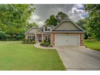Charming brick home featuring a well-manicured lawn, two car garage, and welcoming walkway at 9187 Plantation Cir, Covington, GA 30014