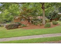 Charming brick home with a beautifully landscaped front yard and mature trees at 1693 Alderbrook Ne Rd, Atlanta, GA 30345