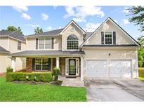 Charming two-story home featuring a well-manicured lawn, covered porch, and a two-car garage at 273 Baywood Xing, Hiram, GA 30141