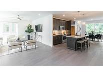 Bright and airy living room with hardwood floors flowing into the kitchen with a granite island and modern appliances at 371 Grant Cir # 1813, Atlanta, GA 30315