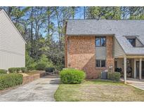 Brick exterior featuring an attached carport, manicured lawn, and verdant foliage at 2459 Cedar Canyon Se Ct, Marietta, GA 30067