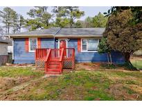 Charming blue single-story home featuring a red porch, red shutters, and a well-maintained front yard at 32 Hillcrest Drive Southeast Se Dr, Austell, GA 30168