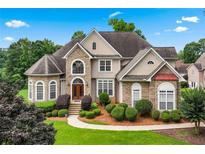 Charming stone and stucco home featuring mature landscaping and a well-manicured lawn at 106 April Walk, Mcdonough, GA 30253