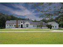 Expansive white home with a well manicured lawn and classic black accents at 1169 Hodges Cir, Mansfield, GA 30055