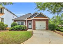 Charming single-story brick home with a well-manicured lawn and attached one-car garage at 401 Buckboard Ln, Locust Grove, GA 30248