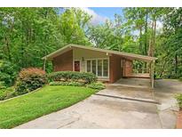 Charming brick home with a well-manicured lawn, lush landscaping, and attached covered parking at 1103 Lee Ne Cir, Atlanta, GA 30324