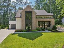 Stunning brick home with modern windows, well-manicured lawn and an attached two car garage at 477 Michael Dr, Alpharetta, GA 30009