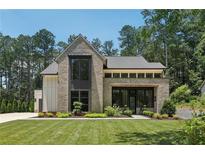 Stunning two-story brick home with a manicured lawn and contemporary design details at 477 Michael Dr, Alpharetta, GA 30009