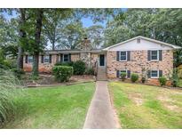 Charming brick home with a stone chimney and lush green lawn at 60 Ivy Dr, Covington, GA 30016