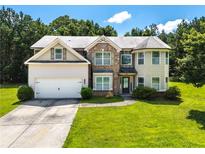 Charming two-story home featuring brick and siding, a well-manicured lawn, and an attached two-car garage at 1492 Station Ridge Ct, Lawrenceville, GA 30045