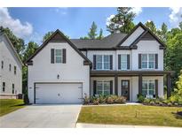 Charming two-story home featuring white brick, dark accents, a two-car garage, and a welcoming front porch at 841 Keystone Dr, Woodstock, GA 30188