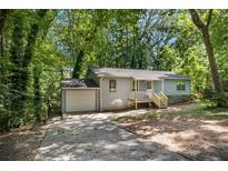 Charming single-story home with a welcoming front porch and driveway at 303 Nottingham Dr, Woodstock, GA 30188