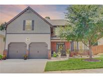 Charming two-story home with a well-manicured lawn, mature landscaping, and a two-car garage at 312 Sierra Ct, Mcdonough, GA 30253