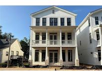 Two-story home featuring a welcoming double-door entrance and a charming, columned porch on both levels at 60 Linton St, Woodstock, GA 30188