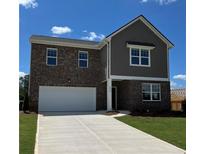 Two-story home featuring a two-car garage, brick facade and a well-manicured lawn at 2289 Argento Cir, Dacula, GA 30019
