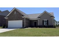 Charming single-story home with a brick facade, attached garage, and well-manicured lawn at 2308 Argento Cir, Dacula, GA 30019