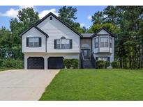 Charming two-story home featuring a two-car garage, manicured lawn and a traditional design at 397 Lovejoy Cir, Powder Springs, GA 30127