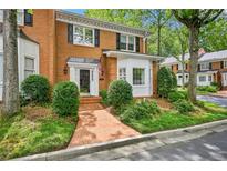 Charming brick townhome featuring lush landscaping and a welcoming brick pathway to the front door at 5427 Trentham Dr, Atlanta, GA 30338