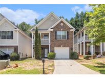 Charming two-story home with brick facade, second-story balcony, and attached one-car garage at 6341 Lake Valley Pt, Lithonia, GA 30058