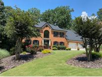 Beautiful brick home with a two-car garage, manicured lawn, and well-maintained landscaping at 710 Larkspur Nw Blvd, Acworth, GA 30102