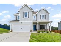 Charming two-story home featuring a two-car garage, light gray siding, dark shutters, and a bright blue front door at 230 Waters Edge Pkwy, Temple, GA 30179