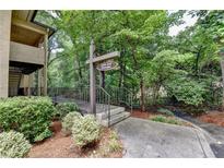 Community entrance sign with lush greenery and mature trees around walkway and building at 1010 Donegal Se, Smyrna, GA 30080