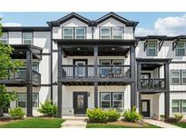 Charming townhome with a covered porch and classic black-and-white trim offers inviting curb appeal at 1104 Knoxboro Ln, Woodstock, GA 30188