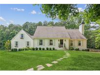 Charming home featuring a beautifully landscaped front yard and inviting stone pathway to the front door at 5095 Karr Road Rd, Cumming, GA 30040