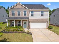 Charming two-story home featuring a brick and siding exterior, manicured lawn, and attached two-car garage at 113 Poppy St, Mcdonough, GA 30253