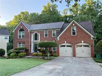 Charming two-story brick home with well-manicured lawn and a two car garage at 545 Ashvale Overlook, Alpharetta, GA 30005