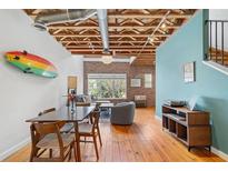Bright open living area with exposed ceiling, brick accent wall, and hardwood floors at 322 Peters Sw St # 2, Atlanta, GA 30313
