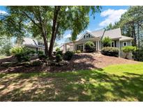 Inviting gray two-story home featuring manicured lawn, mature trees, and tasteful landscaping at 4882 Rabbit Farm Road Rd, Loganville, GA 30052