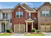 Charming brick townhome featuring a one-car garage and well-manicured landscaping at 1384 Dolcetto Nw Trce, Kennesaw, GA 30152