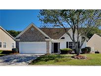Charming single-story home featuring a two-car garage, a manicured lawn, and mature trees at 145 Charleston Pl, Covington, GA 30016