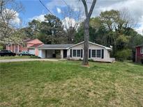 Charming single-story home featuring a carport, brick accents, and a well-maintained front yard at 2830 Norgate Ln, Decatur, GA 30034