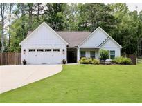 Charming single-story home with a well-manicured lawn, attached two-car garage, and inviting front entrance at 688 Harmony Rd, Temple, GA 30179