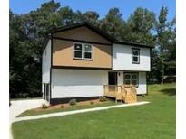 Charming two-story home with a combination of tan and white siding and a well-maintained lawn at 110 Wildwood Dr, Stockbridge, GA 30281