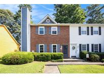 Charming two-story townhome featuring a well-maintained front lawn and colorful landscaping at 1919 Cheatham Woods Sw Dr, Marietta, GA 30008