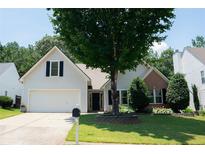 Charming home with manicured lawn, mature tree, and a well-maintained flower bed in the front yard at 3050 Baymount Dr, Lawrenceville, GA 30043