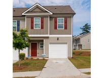 Charming two-story townhome with red shutters, a one-car garage and a well maintained lawn at 3375 Highbury Way, Lithonia, GA 30038