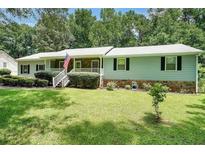 Charming single-story home with a stone accent, well-manicured lawn, and inviting front porch at 180 Kim Trail Trl, Stockbridge, GA 30281